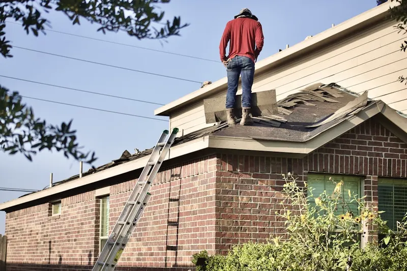 Professional roofer working on a residential roof in Claymont Village